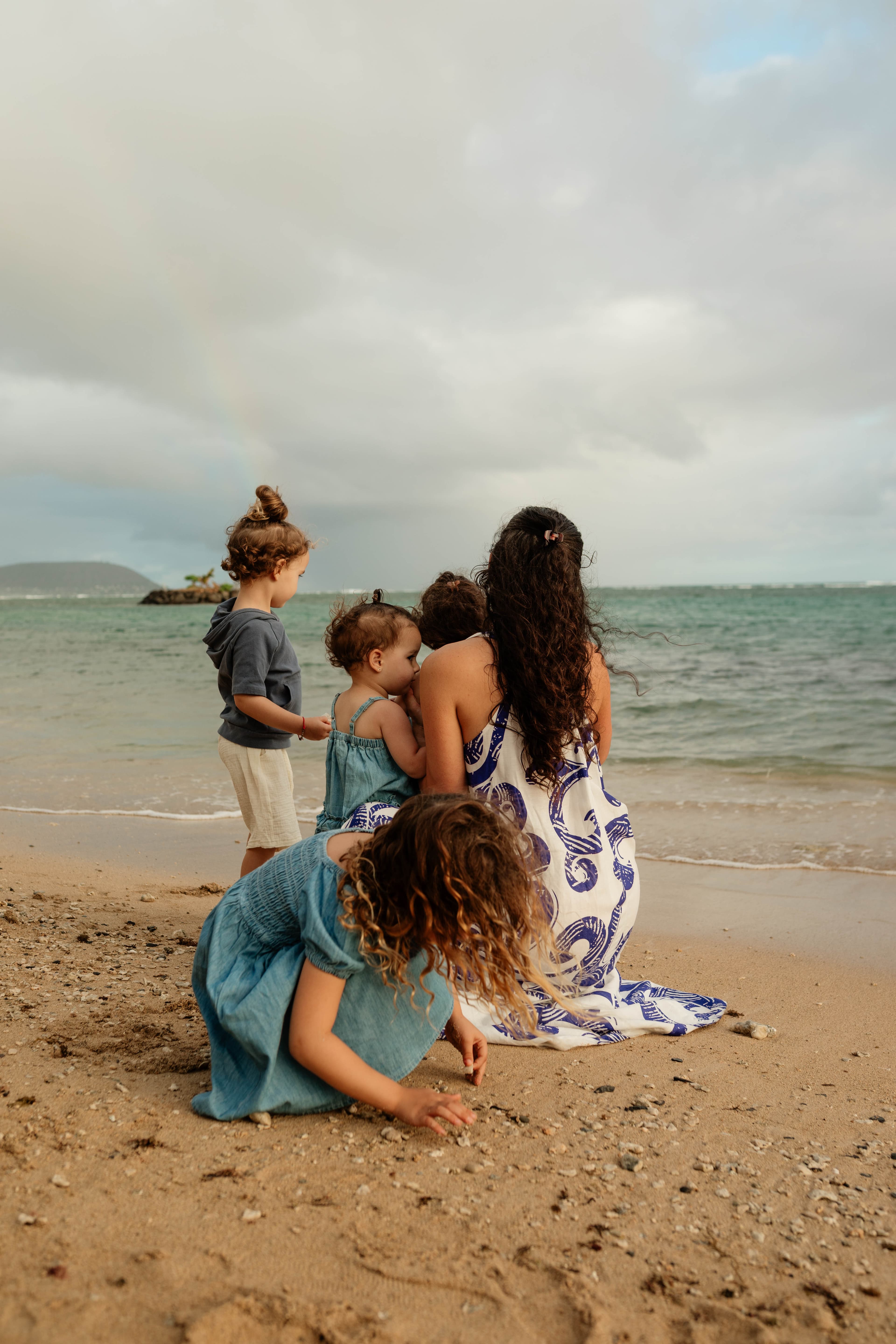 Lina Godfrey with her children on the beach, facing the ocean together